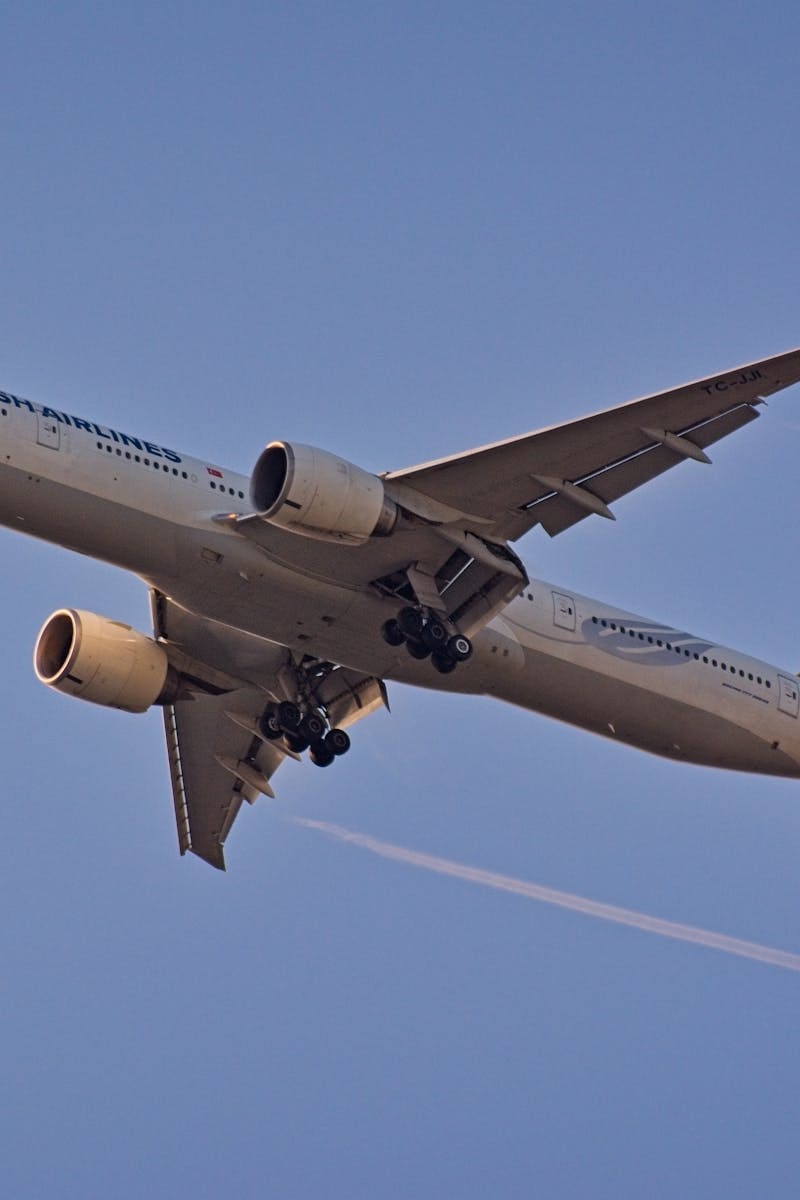 Turkish Airlines Boeing 777 aircraft captured mid-flight against a clear sky.